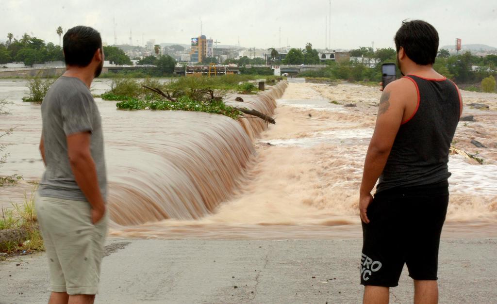 En Sonora, intensas lluvias y fuertes vientos provocados por la tormenta tropical 'Ivo' causaron corrientes de agua que arrastraron varios vehículos, donde una mujer fue rescatada por elementos de tránsito en Ciudad Obregón. (EFE)