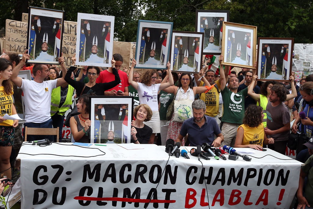 Ayer por la mañana, activistas se manifestaron con fotos de Macron invertidas, como protesta contra sus políticas. (EFE)