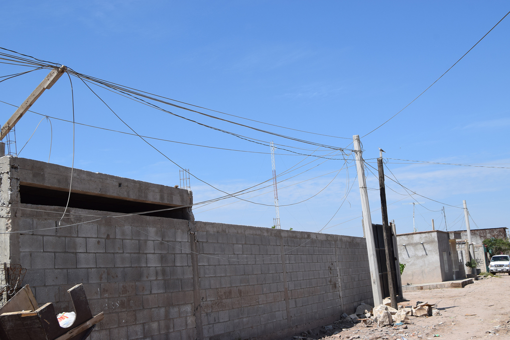 En la colonia se observan unos postes de concreto, pero no cuentan con el tendido eléctrico y las familias siguen 'colgadas'. (EL SIGLO DE TORREÓN/MARY VÁZQQUEZ)