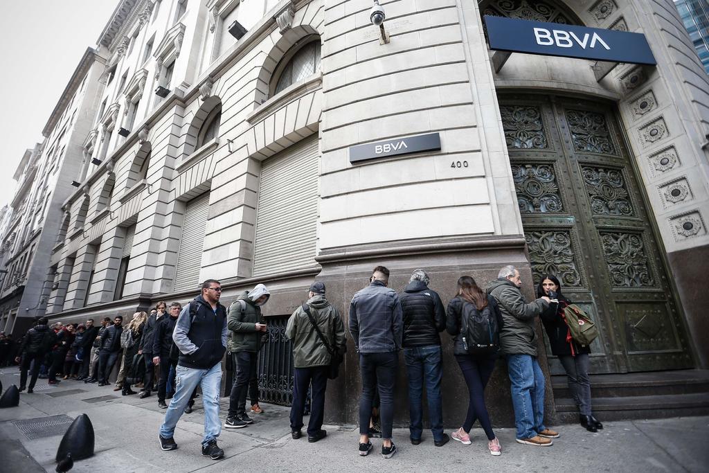 Ante la desconfianza que hay en la economía argentina, cientos intentan sacar sus dólares de los bancos. (EFE)