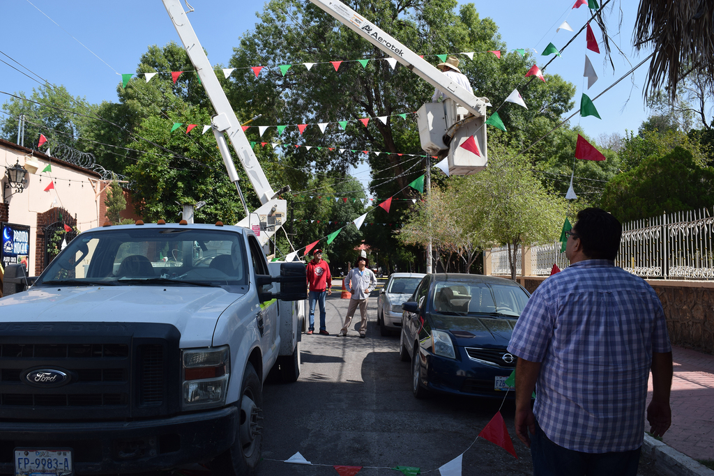 Personal del Municipio coloca los adornos alusivos a las fiestas patrias en las calles. (EL SIGLO DE TORREÒN / MA. ELENA HOLGUÍN)