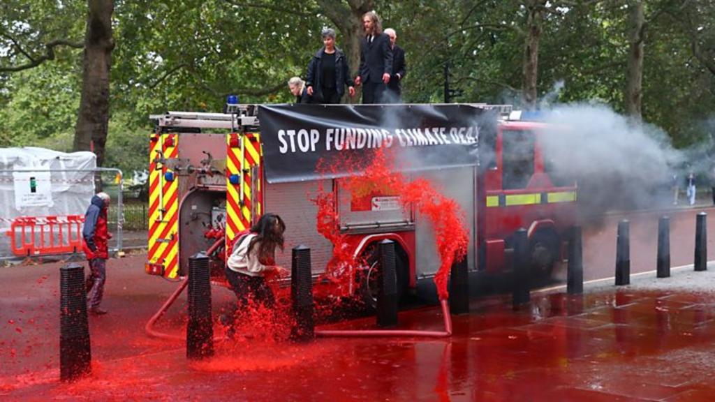 Un grupo ambientalista realizó una protesta este jueves frente al edificio del Ministerio británico de Finanzas en Londres, donde roció agua de color rojo, “sangre falsa”, para instar al gobierno a dejar de financiar proyectos nocivos para el medio ambiente. (ESPECIAL)