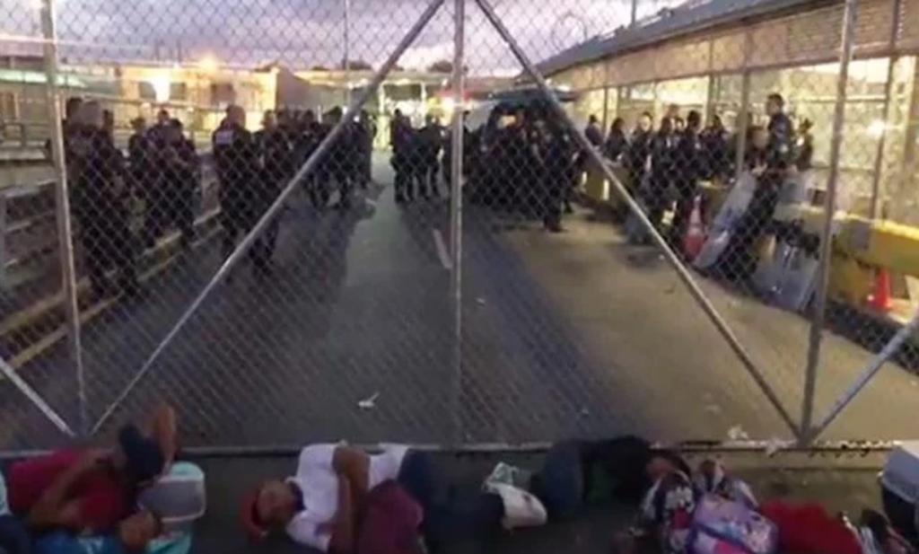Decenas de migrantes que esperan en suelo mexicano mientras Estados Unidos procesa su solicitud de asilo acamparon en un puente internacional que conecta con Brownsville, en Texas, lo que causó el cierre del paso el jueves. (ESPECIAL)