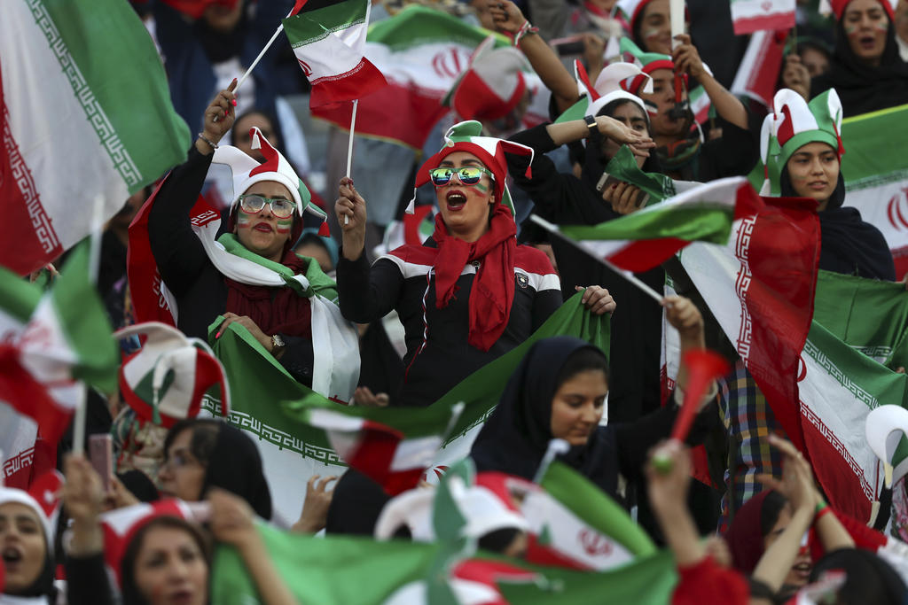 Con banderas iraníes, gorros con los colores nacionales y vuvuzelas, las mujeres comenzaron a animar en un ambiente ensordecedor más de dos horas antes de que arrancara el duelo. (AP)