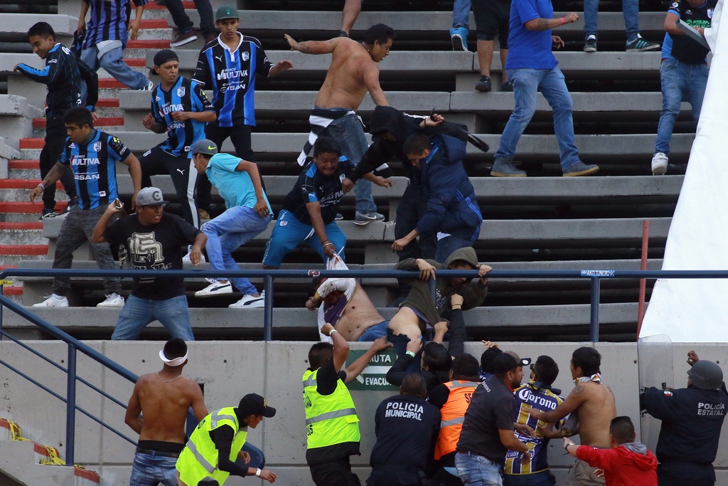 Aficionados queretanos golpean a un hincha rival durante el partido que enfrentó al Atlético de San Luis y los Gallos Blancos. (JAM MEDIA) 