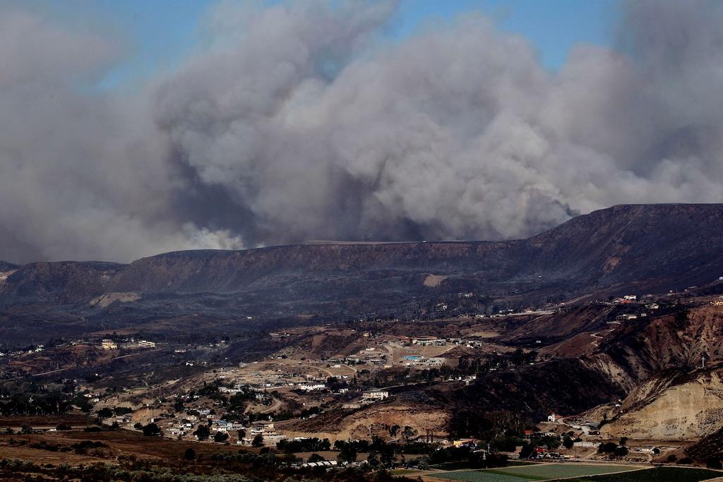 La Coordinación Nacional de Protección Civil (CNPC) informó hoy que suman nueve mil 880 las hectáreas afectadas en los municipios de Ensenada, Tecate, Rosarito y Tijuana, Baja California, debido a los incendios forestales causados por los vientos de Santa Ana. (ARCHIVO)