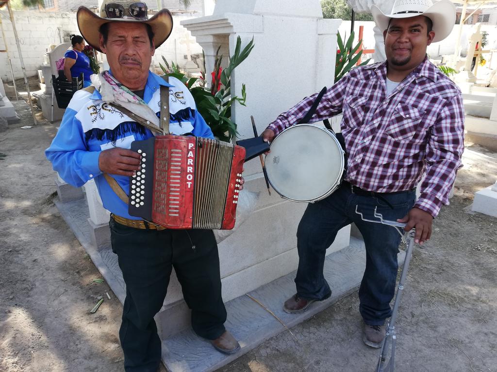 Enrique y Francisco Corpus son músicos de un dúo norteño, quienes ofrecen a las personas sus melodías para cantarles a sus difuntos. (EL SIGLO DE TORREÓN)