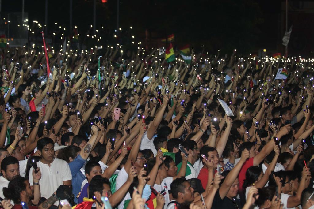 Una multitud de ciudadanos ilumina con sus teléfonos durante la asamblea del comité cívico de la ciudad para decidir medidas de presión contra el presidente boliviano. (EFE)