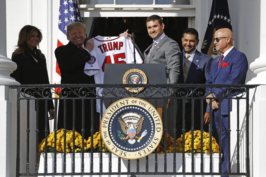 El primera base de los Nacionales de Washington, Ryan Zimmerman (c) entrega una camiseta al presidente de Estados Unidos, Donald Trump ayer durante el evento para celebrar la victoria del equipo en la Serie Mundial. (AP)