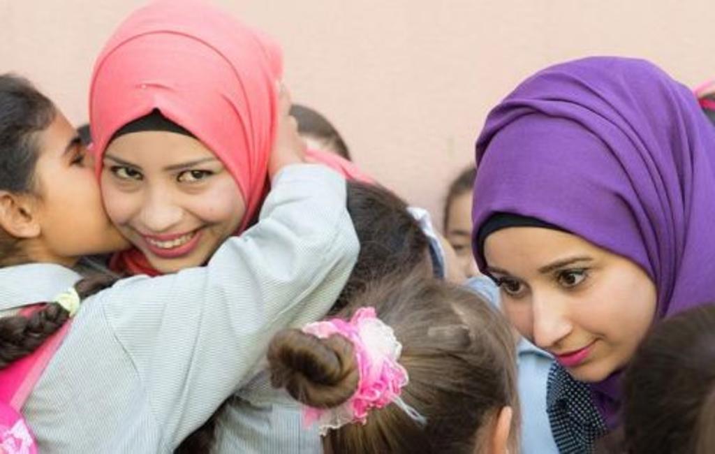 Las maestras voluntarias de la ONU, Farah Chahine y Layal Ammar, hablando y abrazando a sus alumnos en la escuela Ramallah, en el campo de refugiados palestinos de Chatila. (NACIONES UNIDAS)