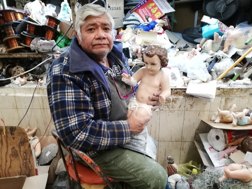 Desde hace 40 años Juan, le reza al Niño Dios cuando los repara en su local del Mercado Juárez. (EL SIGLO DE TORREÓN/VIRGINIA HERNÁNDEZ)
