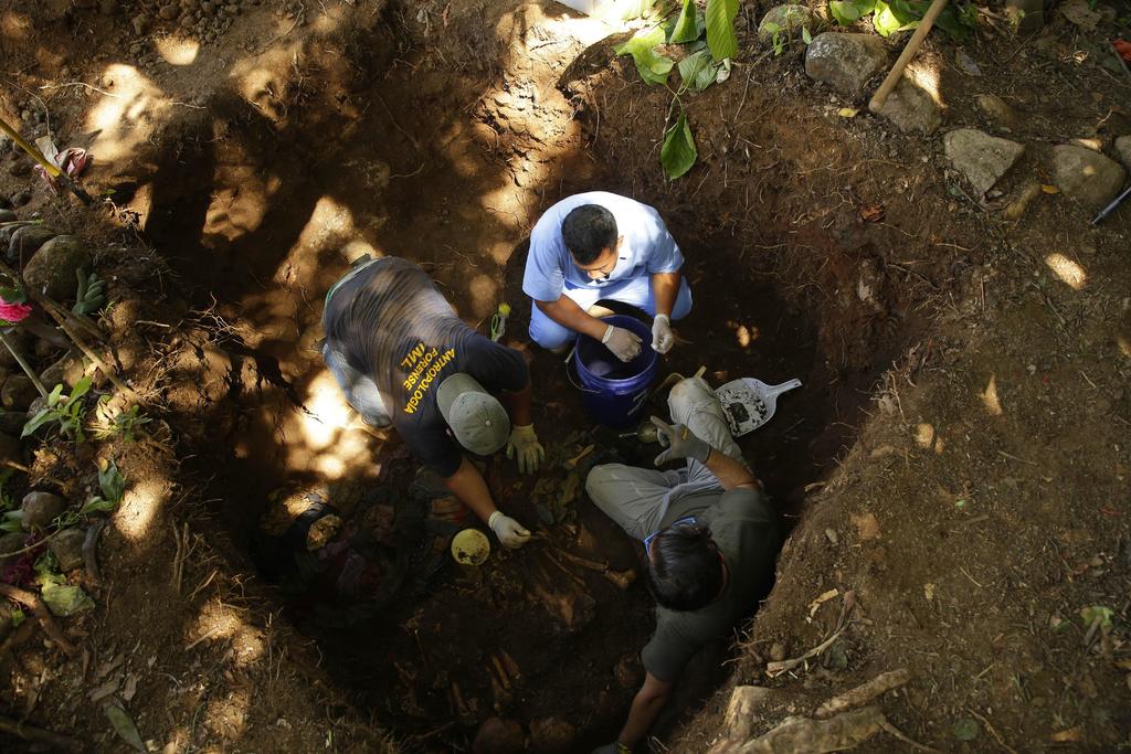 Antropólogos forenses durante la exhumación de restos humanos, víctimas de la matanza de El Mozote. (ARCHIVO) 