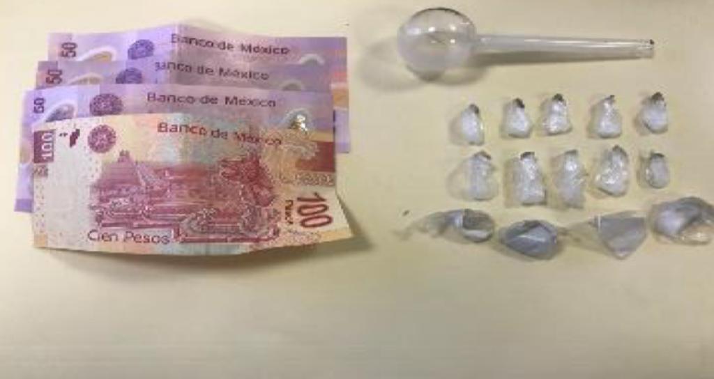 Se les encontraron 14 envoltorios pequeños con una sustancia semigranulada, la cual reúne las características de la droga conocida como cristal, además de 250 pesos y una pipa de cristal. (ESPECIAL)