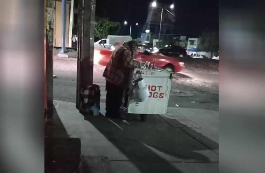En la fotografía se observa al adulto mayor en una esquina de la Avenida Juárez, junto a su carrito de hot dogs, esperando la llegada de algún cliente. (ESPECIAL)