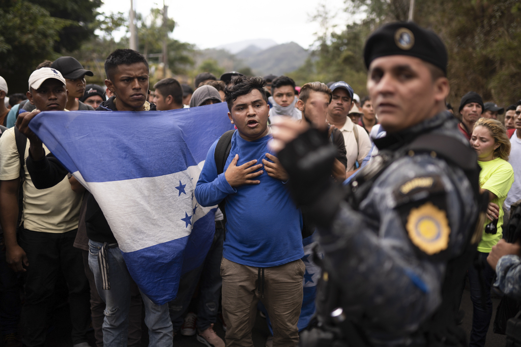 Un oficial de la Policía de Guatemala impide el paso de migrantes hondureños. (AP) 