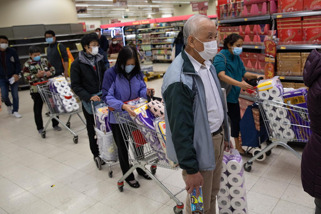 Los clientes que hicieron una fila el viernes en una farmacia en el centro de Hong Kong para comprar papel higiénico dijeron sentirse forzados a abastecerse. (EFE)
