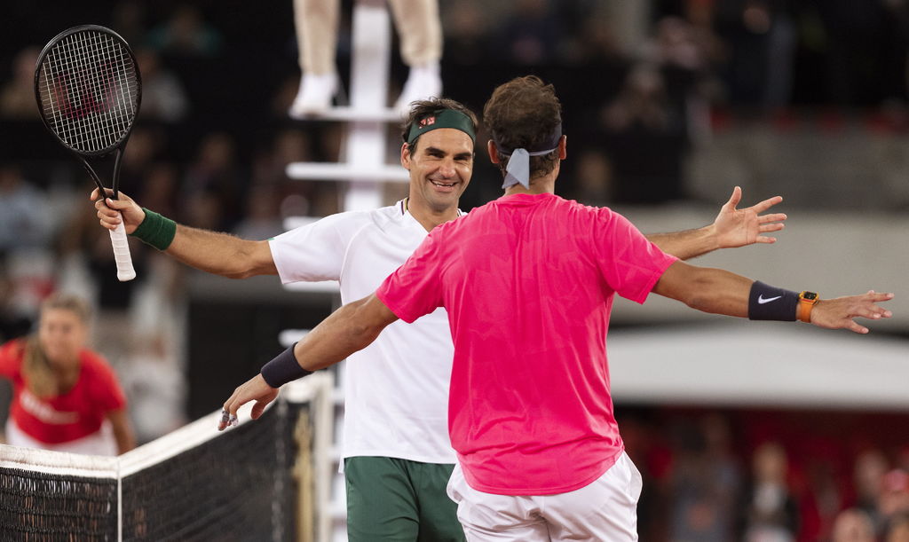 Roger Federer sonríe al abrazar a Rafael Nadal, luego de vencerlo 6-4, 3-6, 6-3, en un partido a beneficio en Sudáfrica; dicho duelo rompió el récord de asistencia para un juego de tenis.  (EFE)