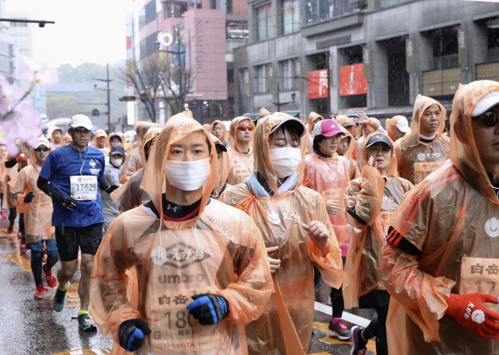 Algunos corredores usan cubrebocas mientras disputan un maratón en la ciudad de Kumamoto, al oriente de Japón. (AP)