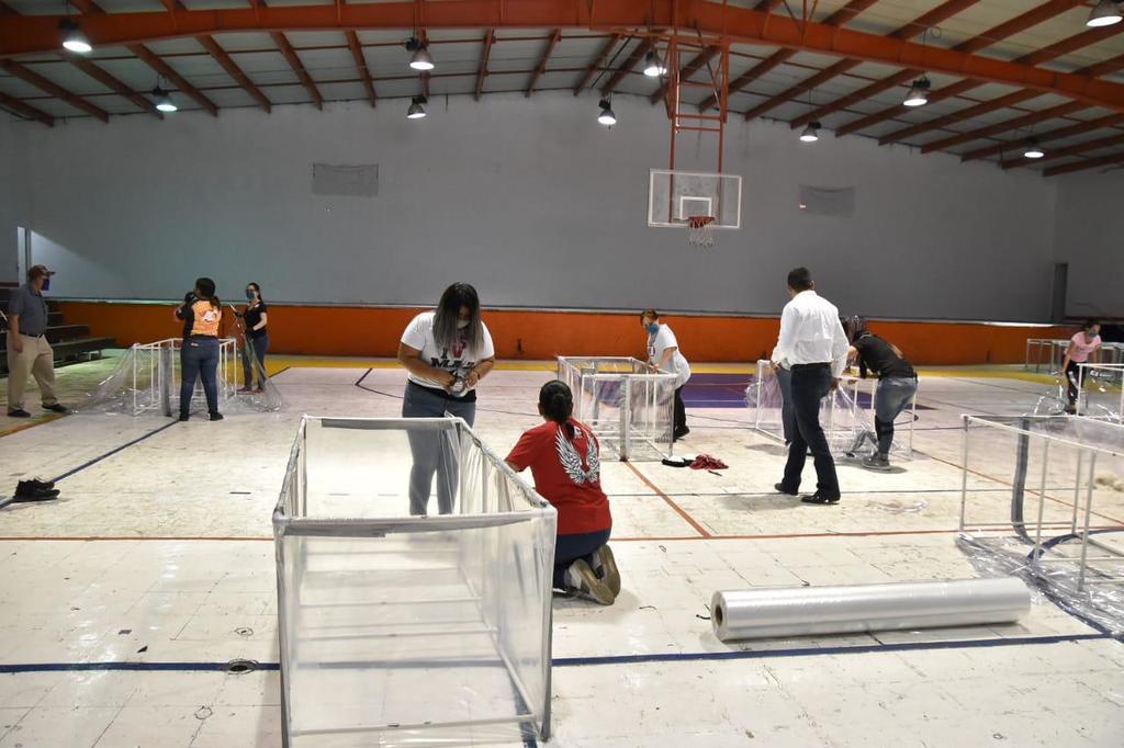 Empleados voluntarios de la presidencia construyen las cápsulas en el auditorio municipal de la ciudad de Monclova.