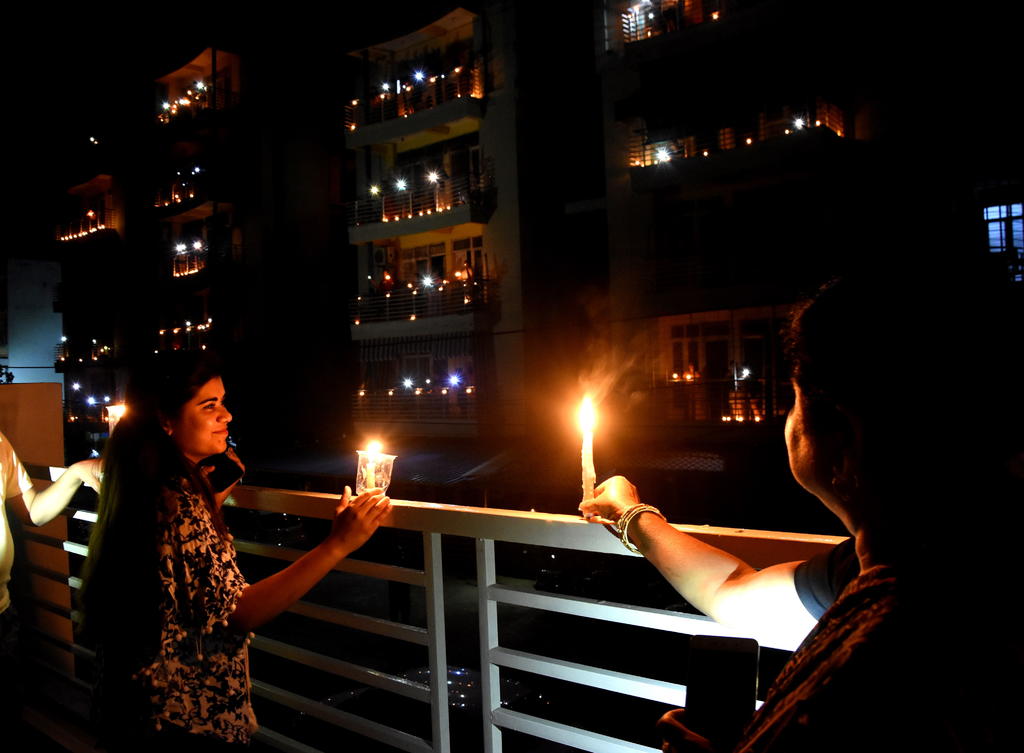 La mayoría de la gente apagó las luces de sus casas a la hora convocada y reunida en las ventanas, balcones o patios, encendió velas y la luz de sus teléfonos móviles. (EFE)