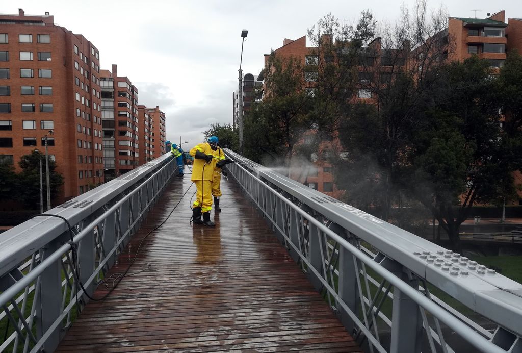Trabajadores de la limpieza del Distrito Capital desinfectan un puente en el norte de la ciudad de Bogotá. (EFE) 