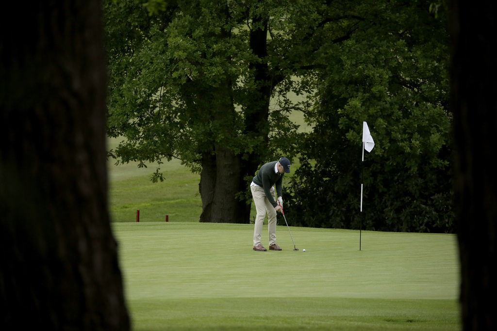 Un golfista sobre el green del Club de Golf Sunningdale, que reabrió sus puertas tras el aislamiento en Inglaterra por el coronavirus. (AP)