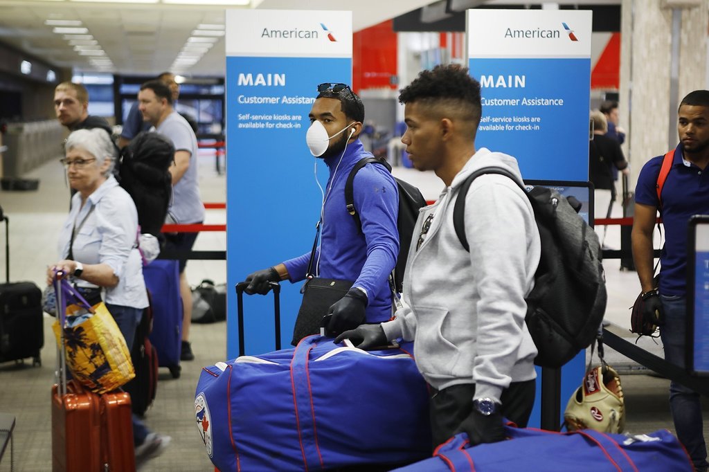 Jesús Navarro, de las ligas menores de los Azulejos de Toronto, porta una mascarilla mientras se prepara para volar a su natal República Dominicana.