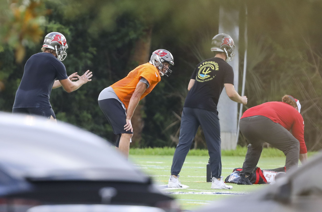 Tom Brady (jersey naranja) entrenó ayer con algunos compañeros en un campo de una escuela secundaria. (AP)