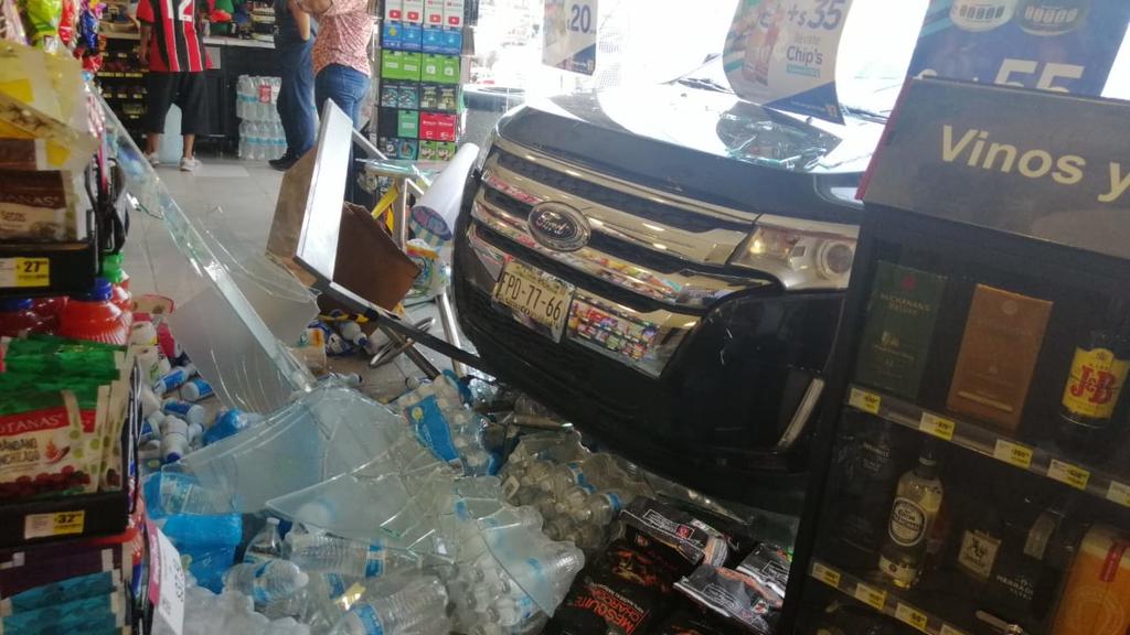 Dentro de la tienda, el conductor impactó la barra de seguridad de metal, así como un estante con abarrotes y botellas de agua purificada. (EL SIGLO DE TORREÓN)