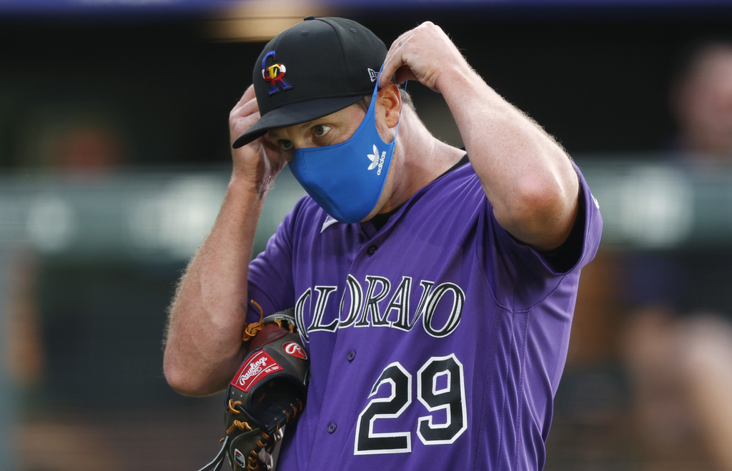 El relevista de los Rockies, Bryan Shaw, se pone un cubrebocas durante un entrenamiento. (AP)