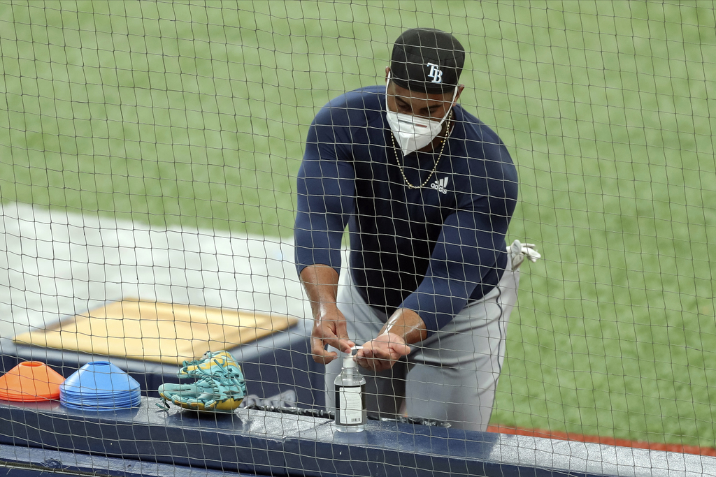Yandy Díaz, de Rays de Tampa, se pone alcohol gel durante una práctica. (AP)