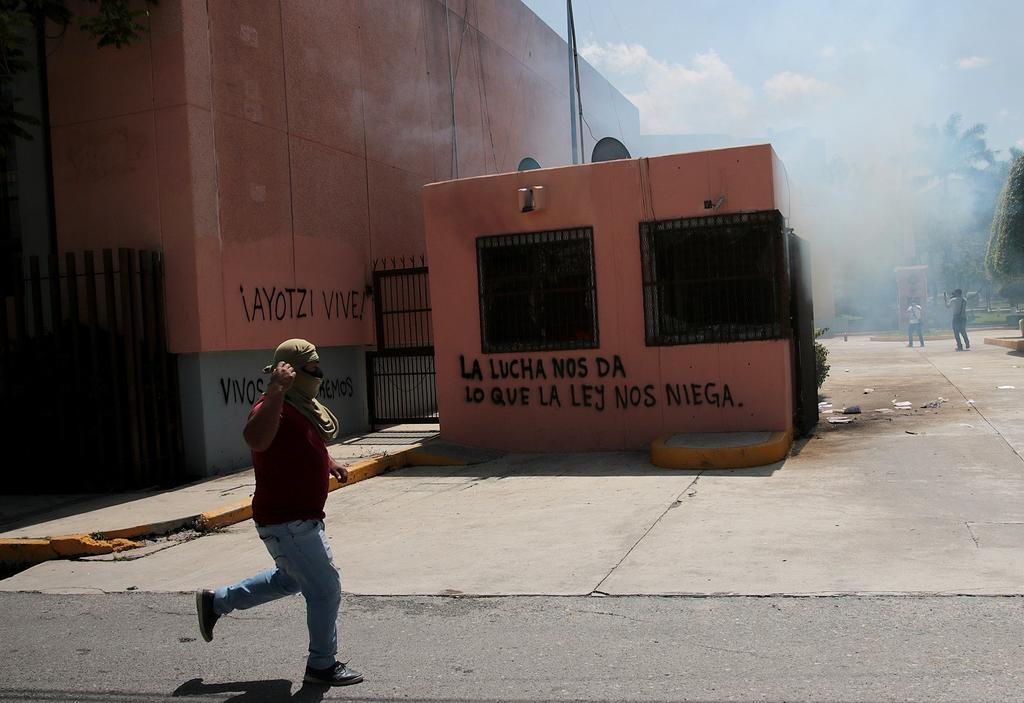 Unos 300 estudiantes de la Escuela Normal Rural de Ayotzinapa lanzaron este viernes cócteles molotov contra la sede del Congreso del sureño estado mexicano de Guerrero, incendiando parte de la fachada y causando desperfectos en oficinas. (EFE)