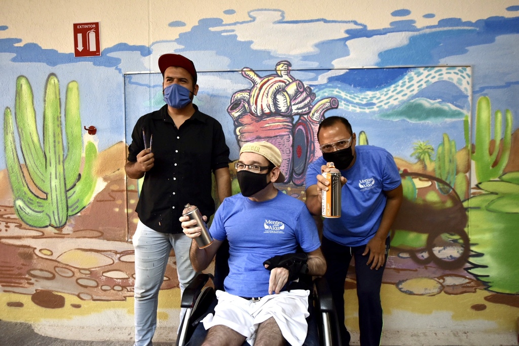 OBRA. Santiago Espericueta, Fernando Berlanga y Jesús Alejandro Sifuentes posan en el mural realizado para Mentes con Alas. (El siglo de Torreón / Erick Sotomayor Ruiz)