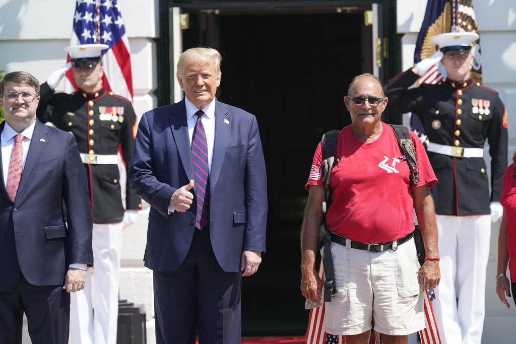 El presidente Donald Trump (i) recibió el lunes en la Casa Blanca al infante de marina Terry Sharpe (d), que inició una caminata desde Carolina del Norte en una campaña de concientización sobre el problema de los suicidios entre los militares veteranos. (EFE) 