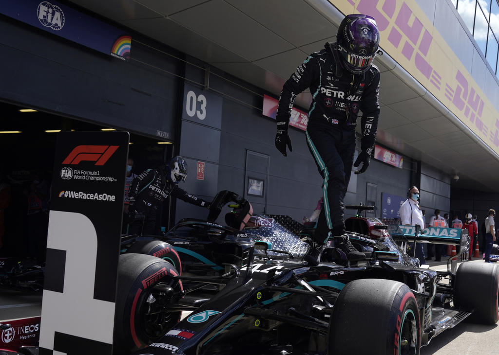 El piloto británico Lewis Hamilton desciende de su monoplaza tras obtener la 'pole' ayer.