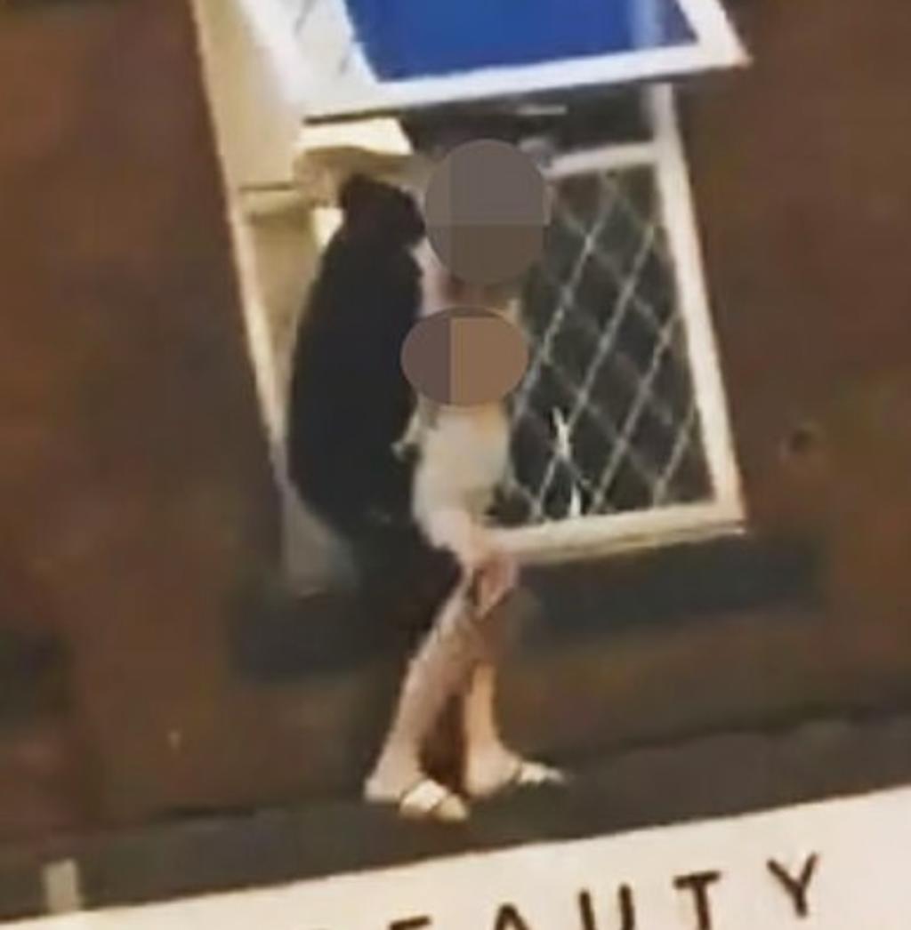 Hombre cuelga desde una ventana mientras carga y menea a un niño