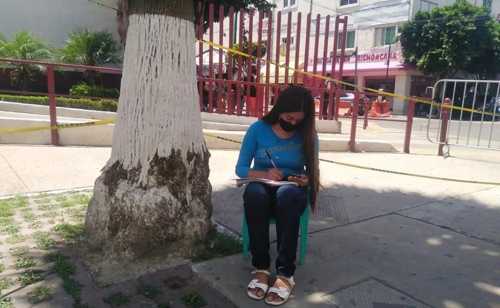 Con su celular, la joven de 14 años toma sus clases con la señal de wifi que capta desde la calle (ESPECIAL) 
