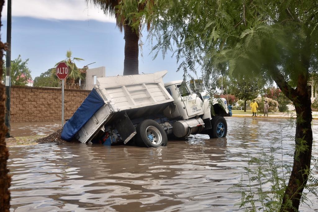 Un camión materialista terminó hundido en plena vialidad en el fraccionamiento Senderos de Torreón tras las precipitaciones de ayer en la mañana. 