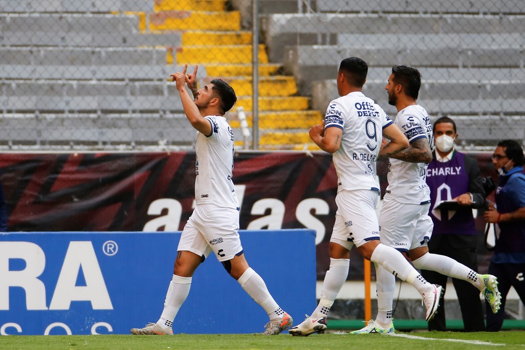 Víctor Guzmán (i) celebra tras marcar de penal el único tanto del partido, en la victoria de los Tuzos sobre Atlas.