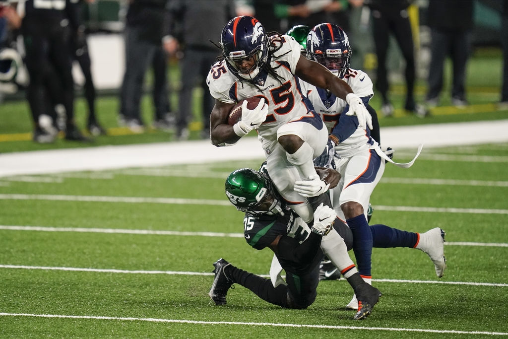 El corredor de los Broncos de Denver, Melvin Gordon supera a defensivos de los Jets de Nueva York, en East Rutherford, Nueva Jersey. (AP)