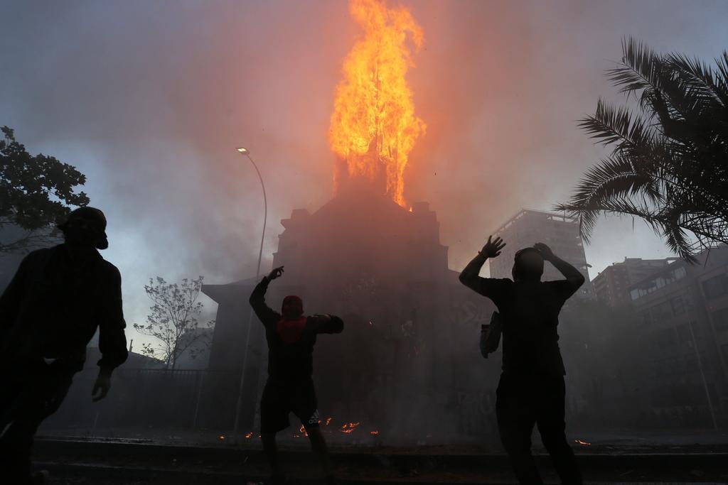 Al menos dos iglesias del centro de Santiago de Chile fueron quemadas este domingo tras la multitudinaria manifestación que congregó a decenas de miles de personas para conmemorar el primer aniversario de ola de protestas, las más graves desde el fin de la dictadura militar (1973-1990). (ARCHIVO)