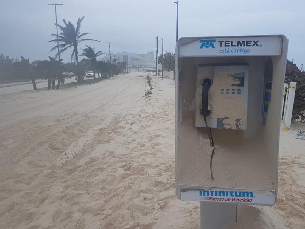 En redes sociales circulan fotografías y videos de la Playa Delfines y el bulevar Kukulcán con una gran cantidad de arena cubriendo el asfalto y las banquetas. (Twitter) 