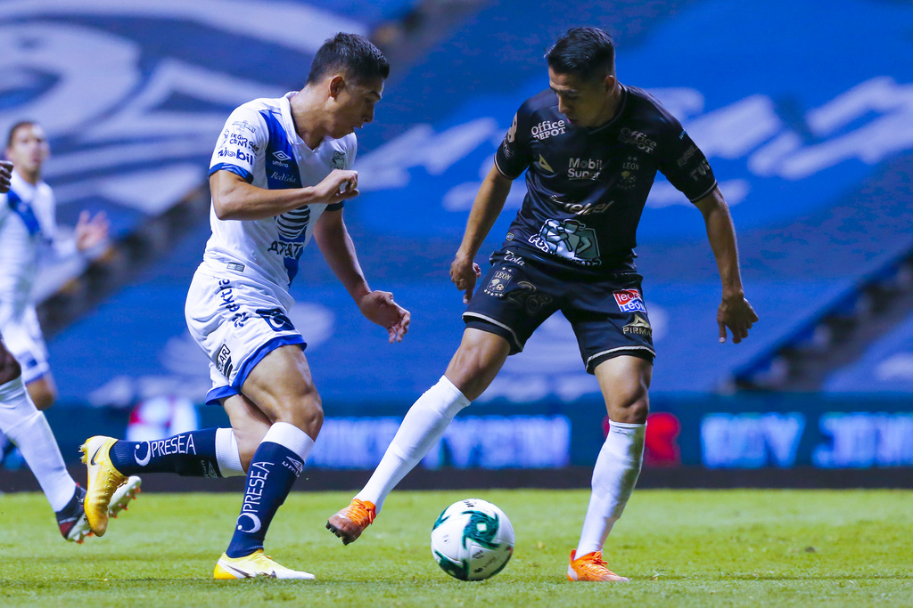 Javier Salas (i) del Puebla y José Ramírez (d) del León disputan el esférico durante el juego de ida de los cuartos en el Cuauhtémoc. (JAM MEDIA)