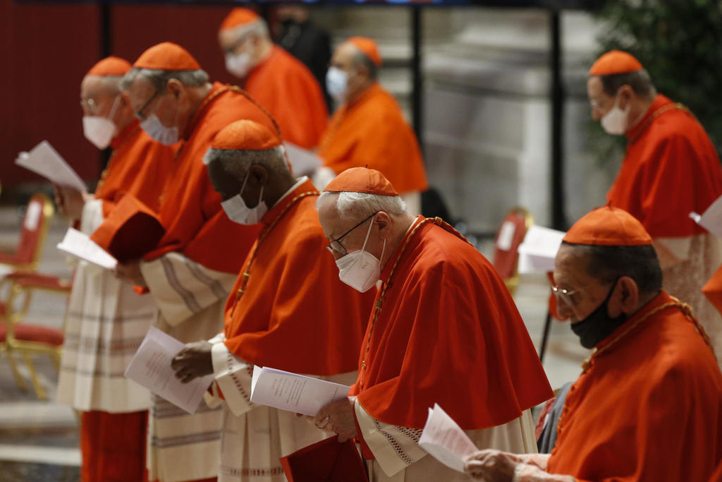 La mayoría se quitó los cubrebocas cuando se acercaron a un Francisco sin mascarilla para recibir sus sombreros rojos. (AP)