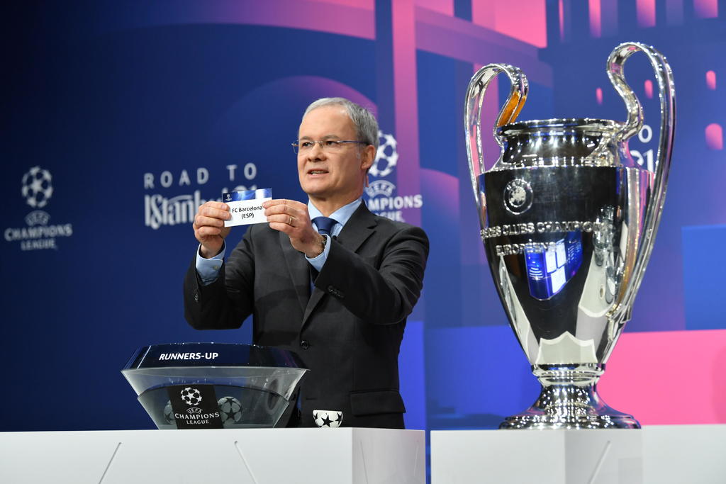 Giorgio Marchetti, secretario general de la UEFA, saca el papel del Barcelona, durante el sorteo de la Champions. (EFE)
