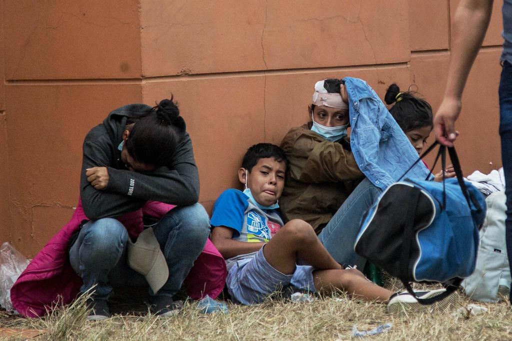 Una familia descansa luego de ser reprimidos por autoridades guatemaltecas, que detuvieron a hondureños que caminan por una carretera, en Chiquimula. (EFE) 