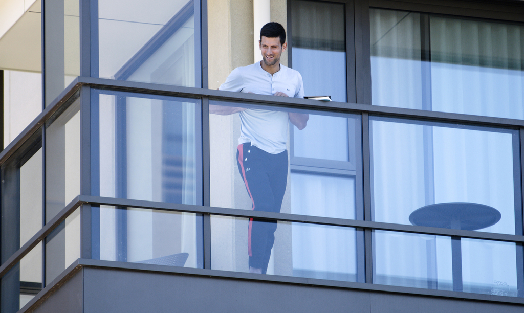 Novak Djokovic desde el balcón de su habitación, donde pasa la cuarentena previo al Abierto de Australia. (AP)