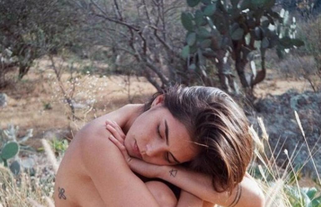 En las imágenes aparece la joven de 24 años de edad sobre una roca posando sentada, cubriendo sus atributos y mostrando sus tatuajes. (Instagram) 