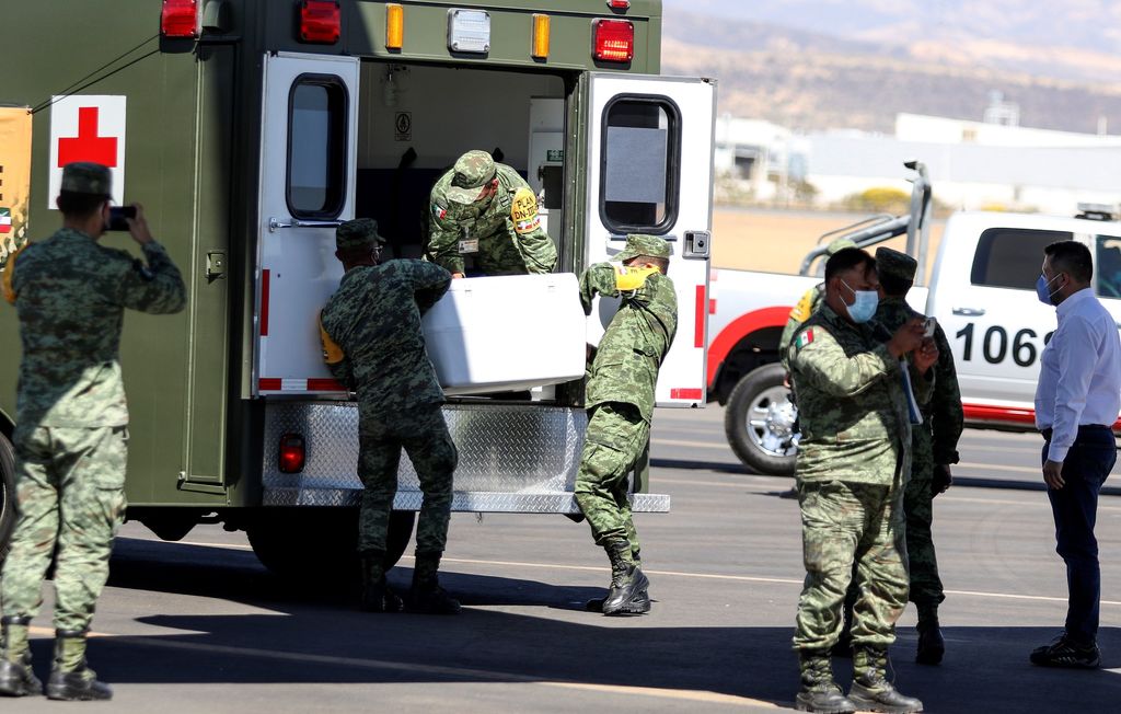 Miembros del Ejército Mexicano descargan contenedores con vacunas de AstraZeneca contra la COVID-19 ayer, en el aeropuerto Internacional de Guanajuato.