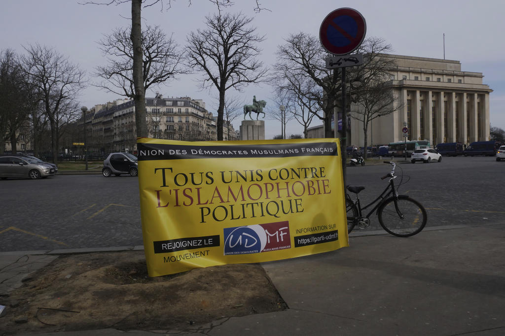 Un cartel que dice 'todos unidos contra la islamofobia' es desplegado en una concentración en París, 14 de febrero de 2021. Los manifestantes se oponen a un proyecto de ley contra el extremismo que dicen atenta contra la libertad religiosa y convierte a todos los musulmanes en sospechosos en potencia. (AP Foto/Thibault Camus)